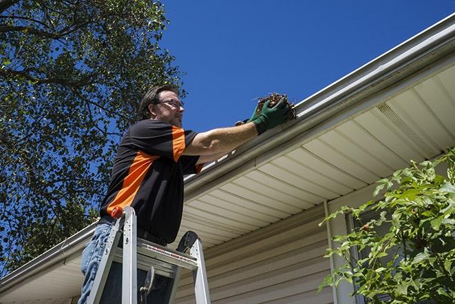 close-up of a technician fixing a gutter pipe in Ashburnham MA